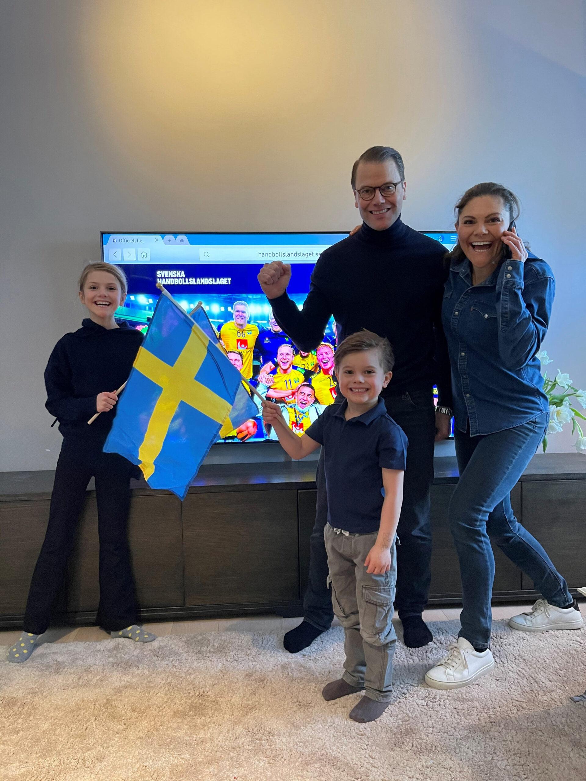 The Crown Princess family waving a flag in front of a telly. Swedish monarchy on a day off.