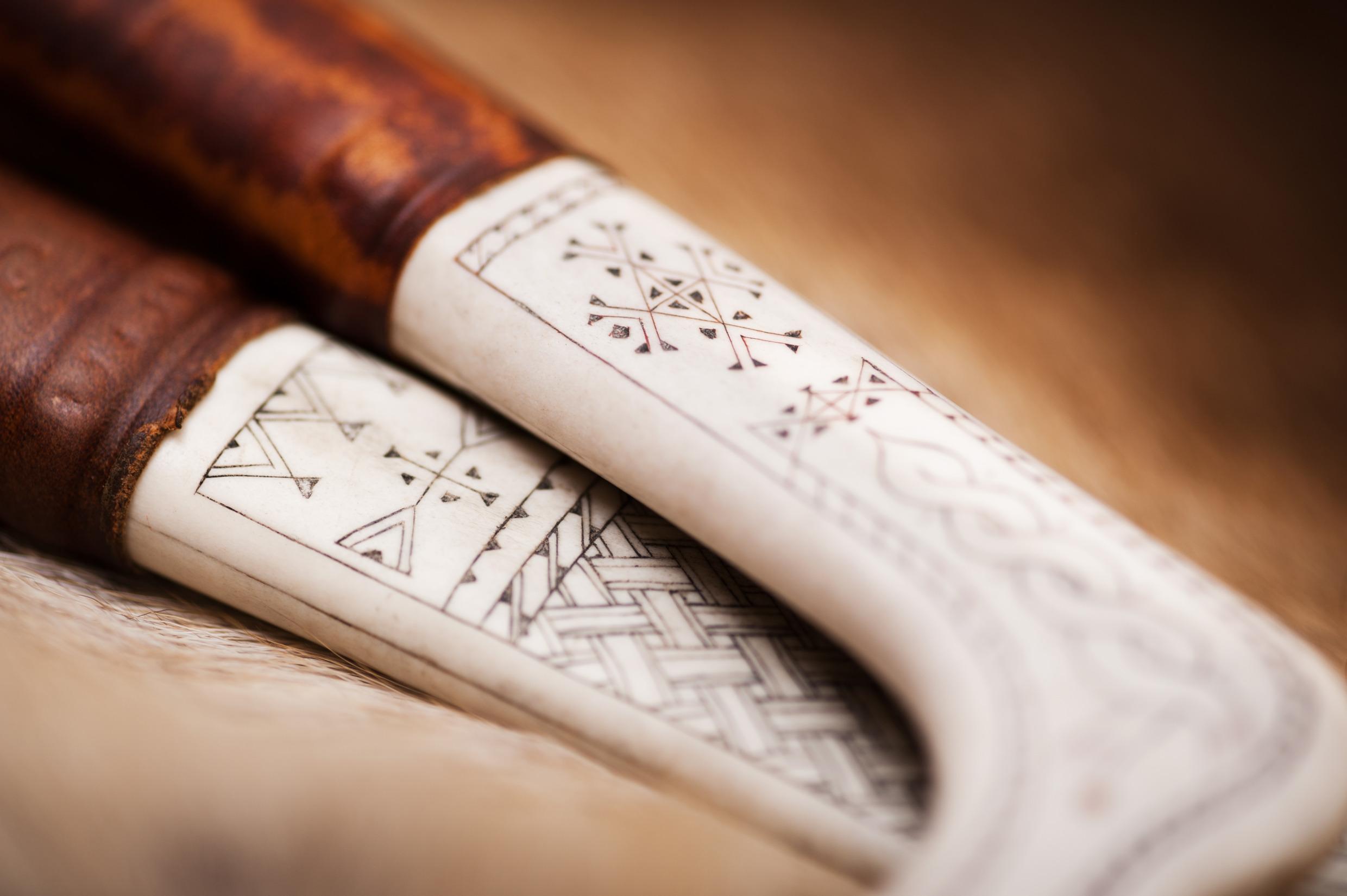 Close-up on two traditional Sami knife. Handmade with a reindeer horn handle decorated with traditional Sami carvings.
