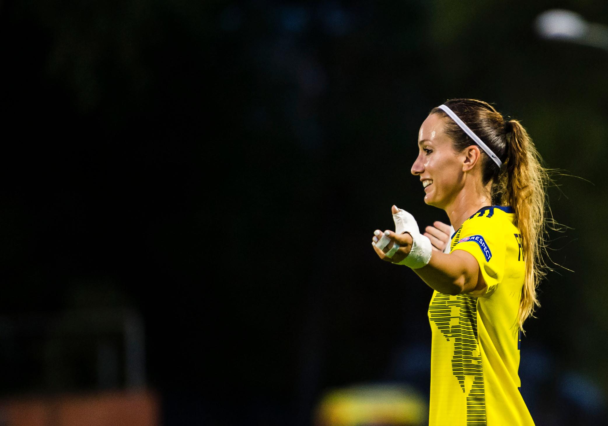 Kosovare Asllani in a yellow Sweden T-shirt with her arms out.