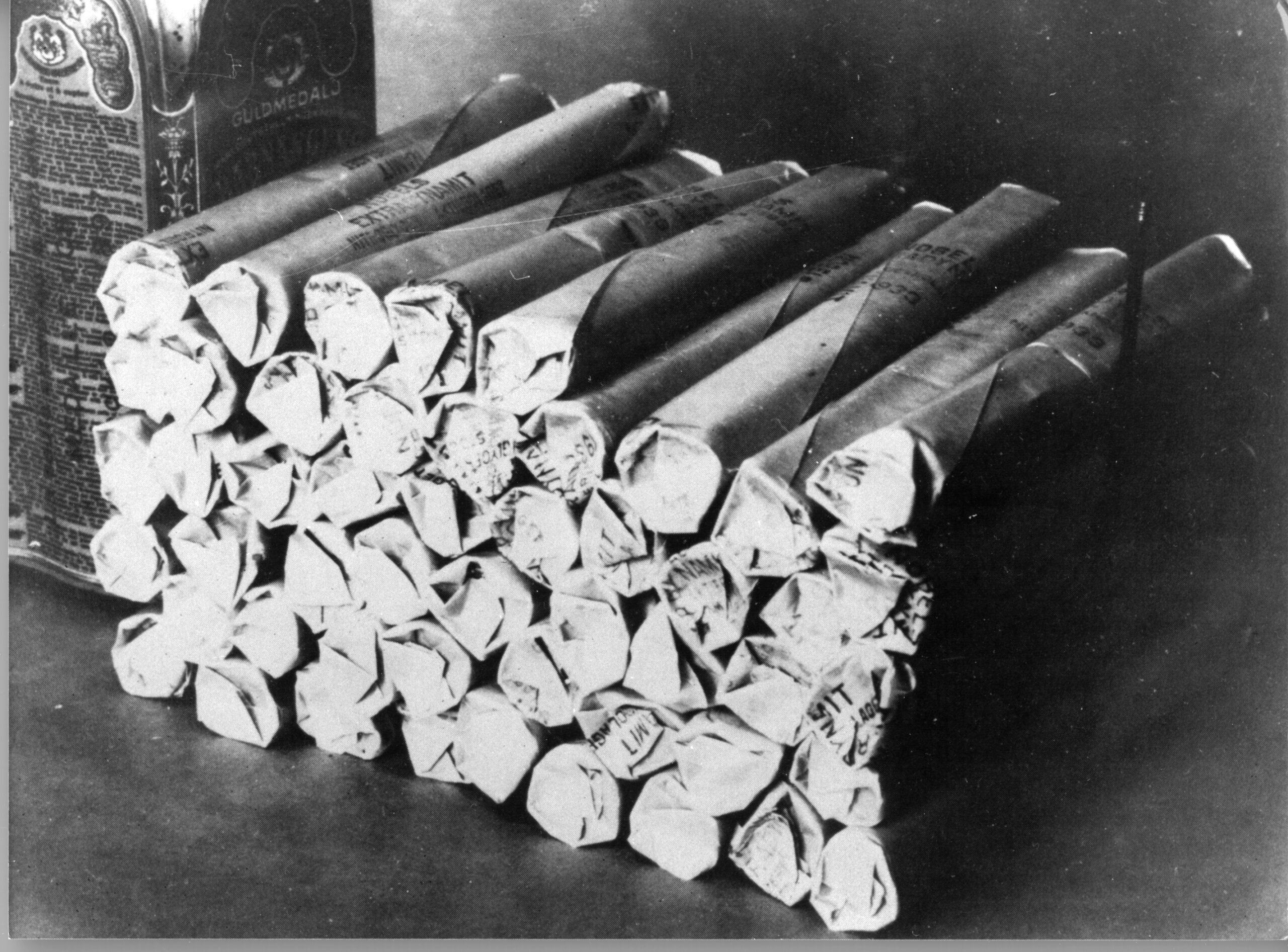A black-and-white photo of a pile of dynamite.