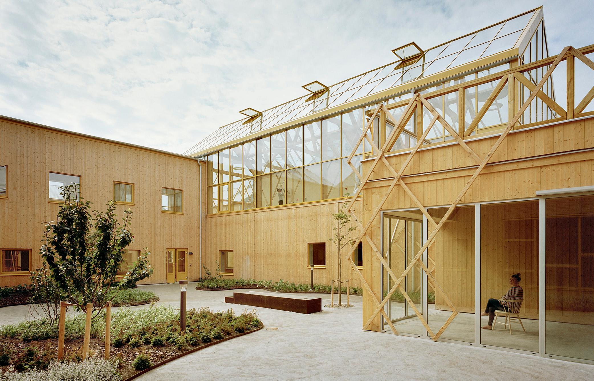 A courtyard with green plants inside a wooden building.