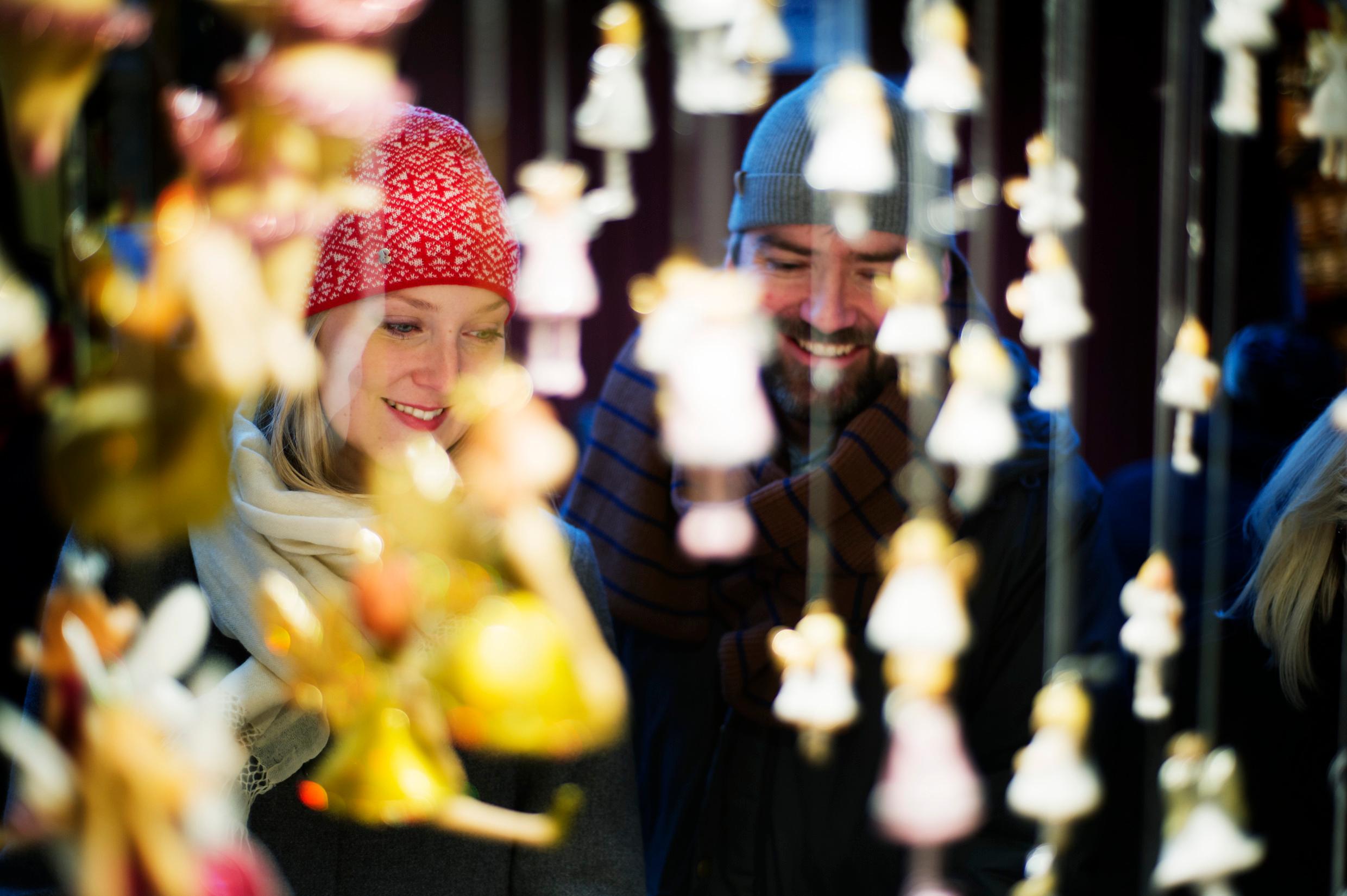 A man and a woman seen through some Christmas decorations.