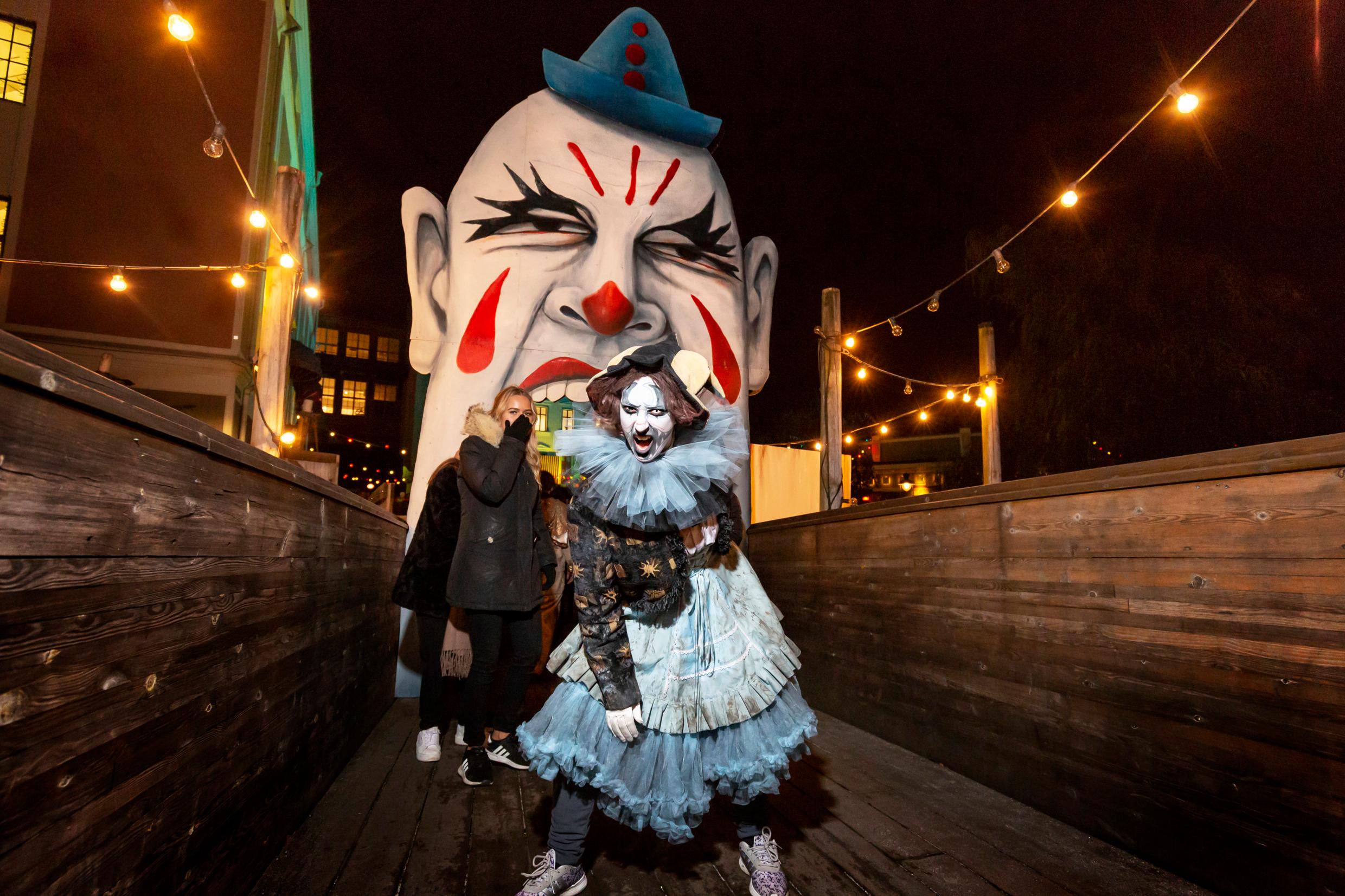 A person dressed up as a zombie at a Halloween fair.