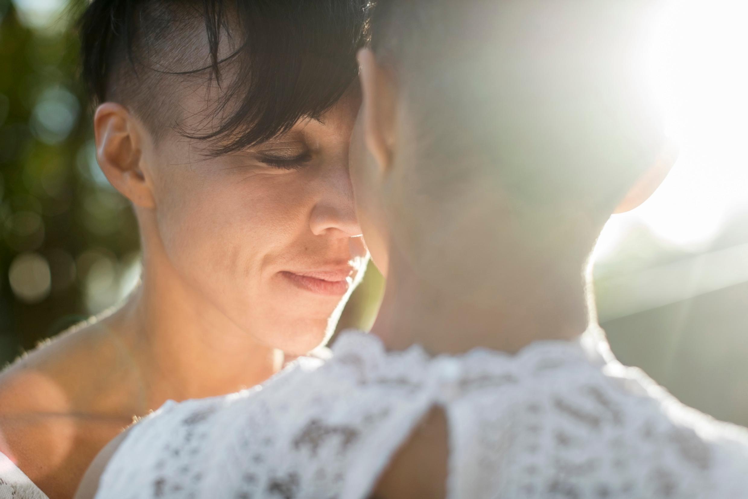 Two women press their foreheads against each other.