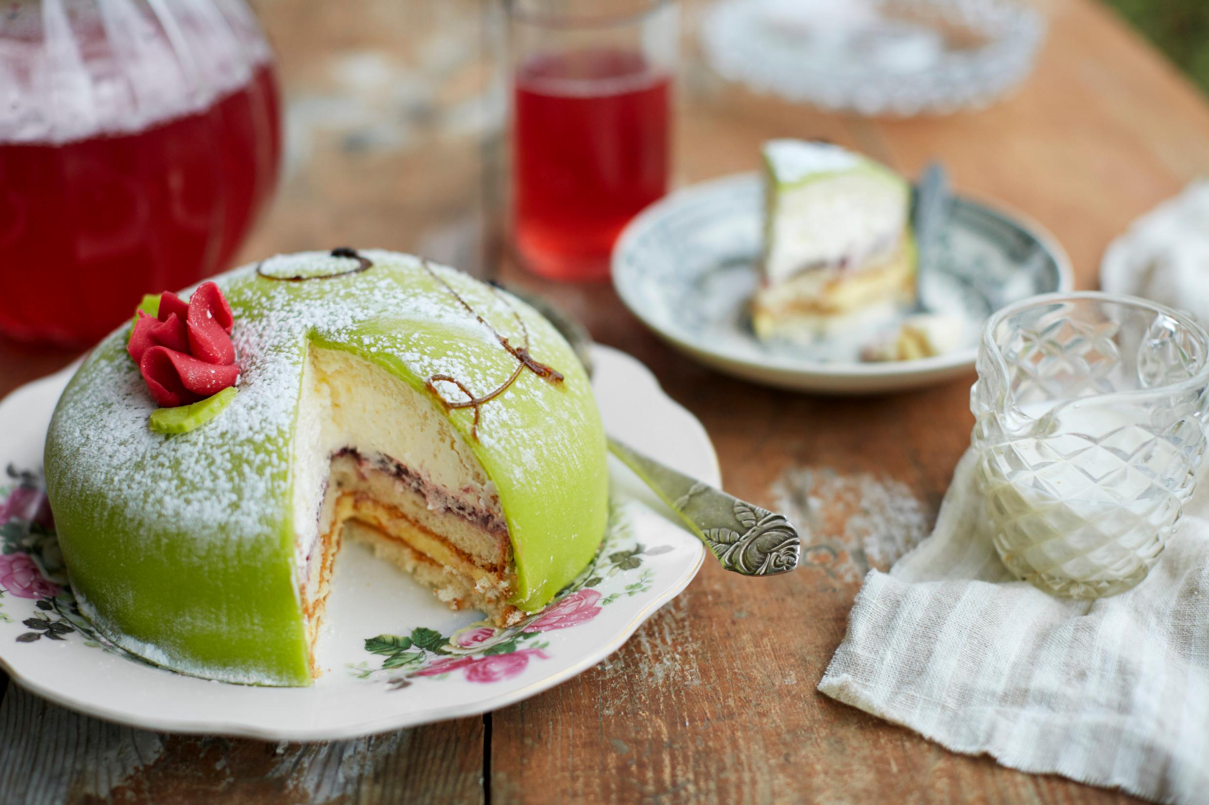 A table is set with Princess cake and pitcher of cordial.