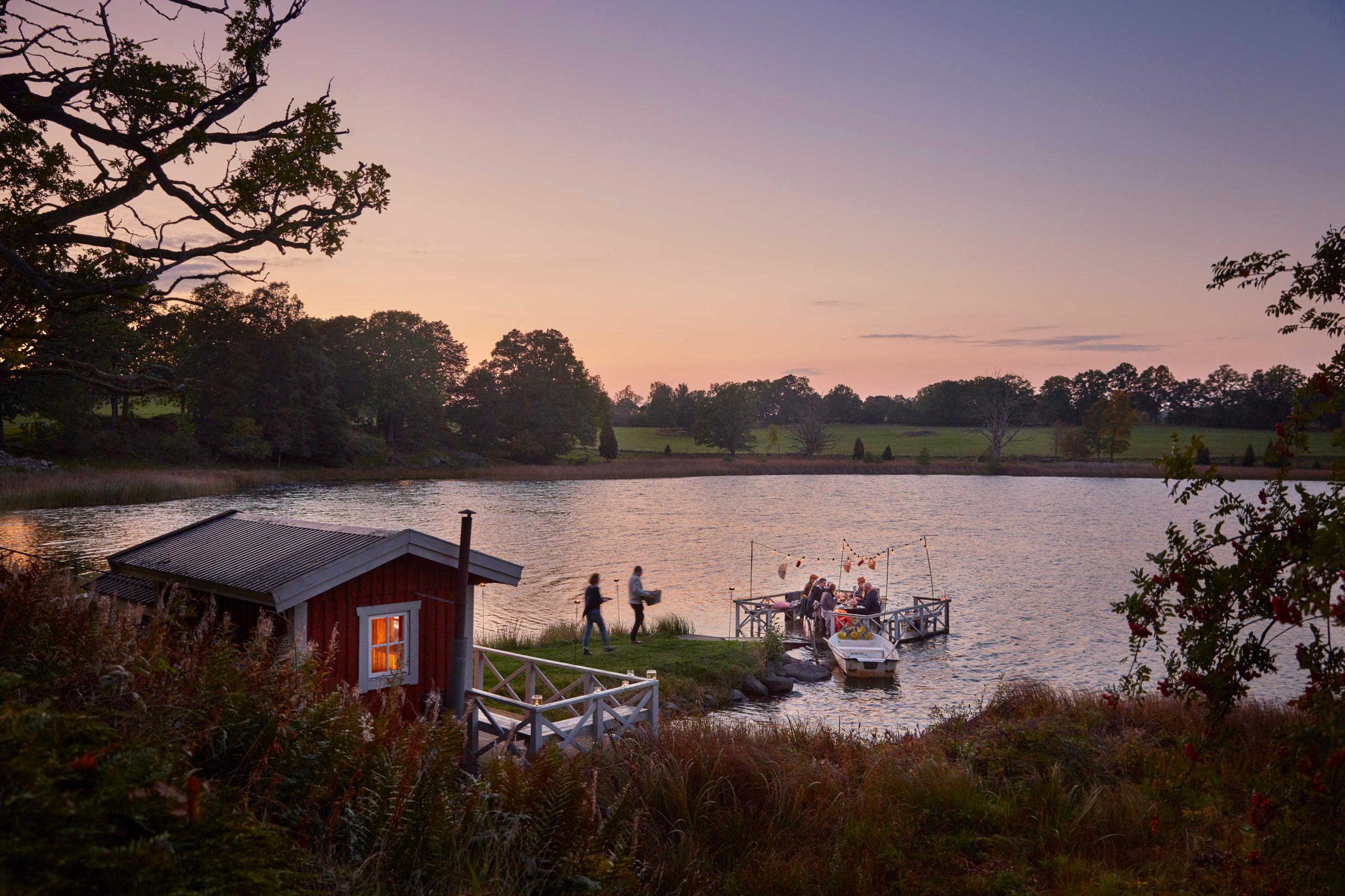 A party on a jetty in a lake, at sunset.