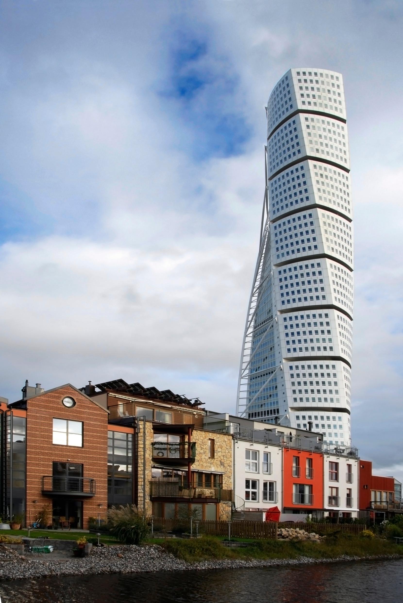 The skyscraper Turning Torso towering over low, colourful buildings.