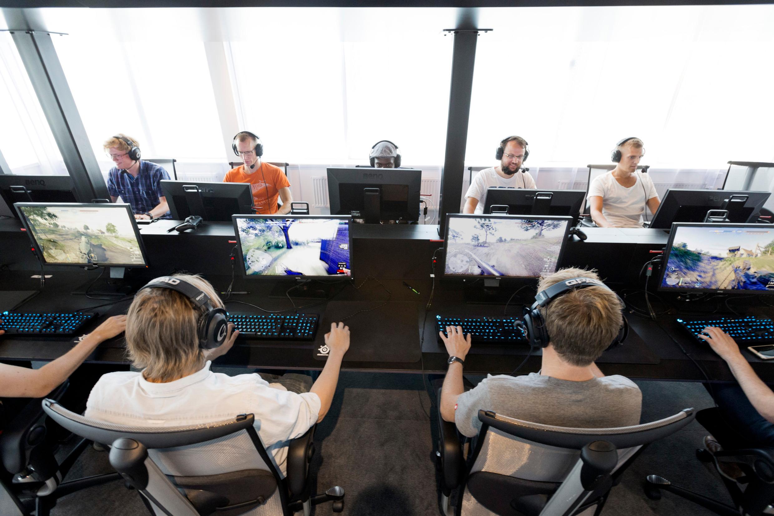 An office where two rows of people are sitting in front of computer screens opposite each other.