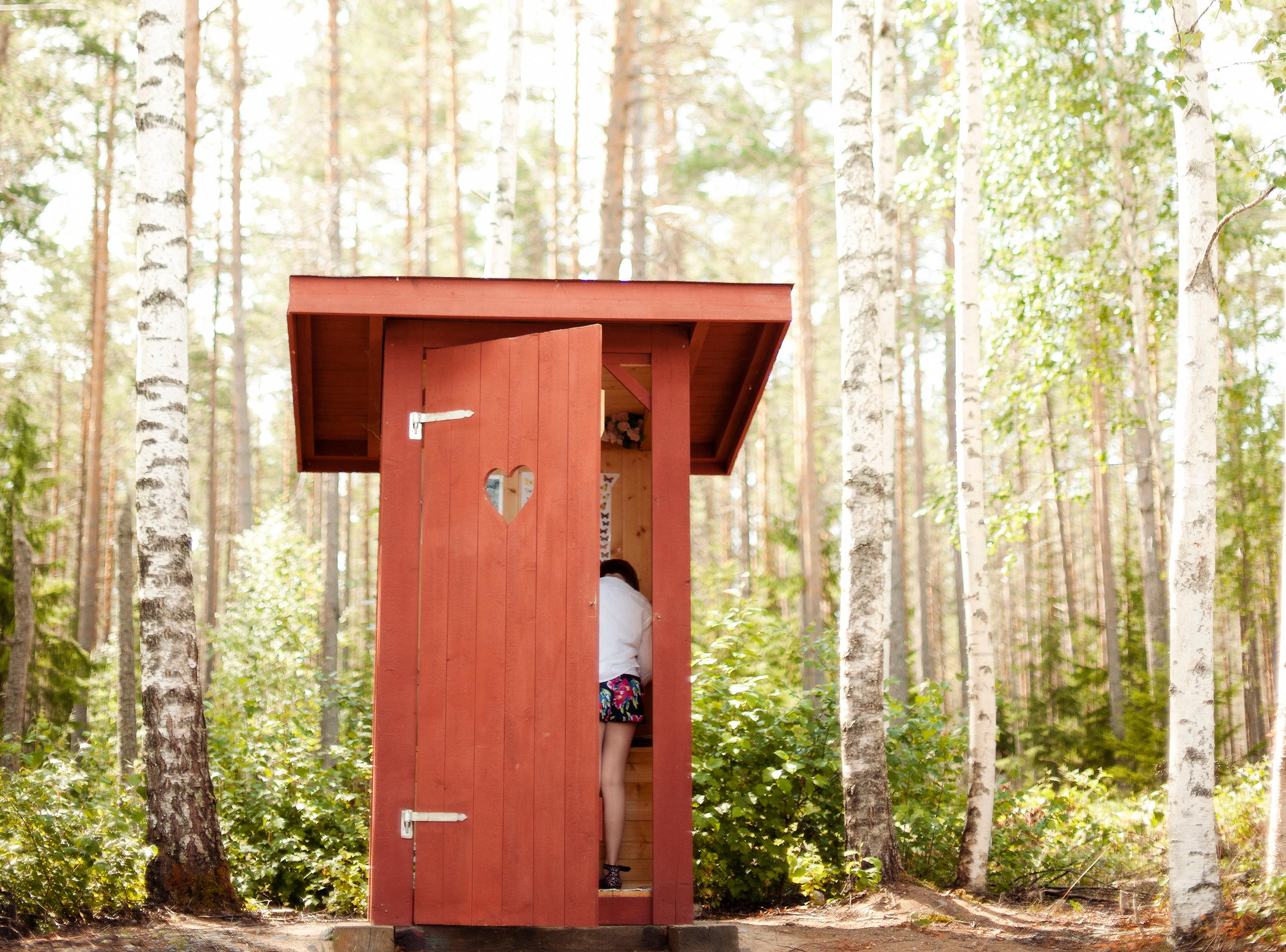 A small red wooden shed, with a heart cut out of the door.