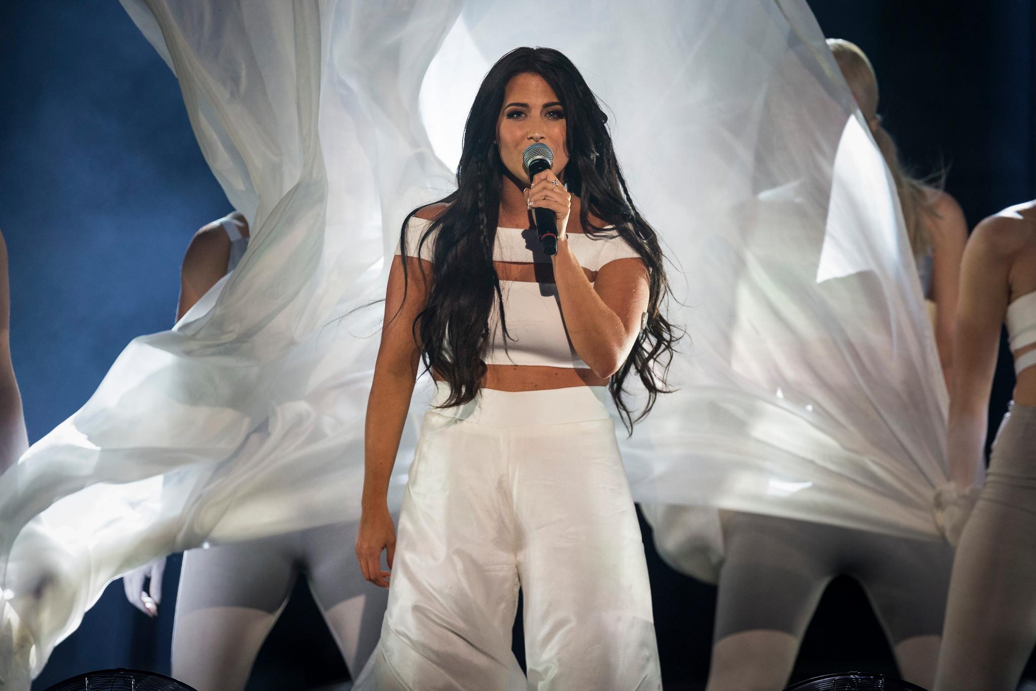 Molly Sandén singing on stage, wearing white.