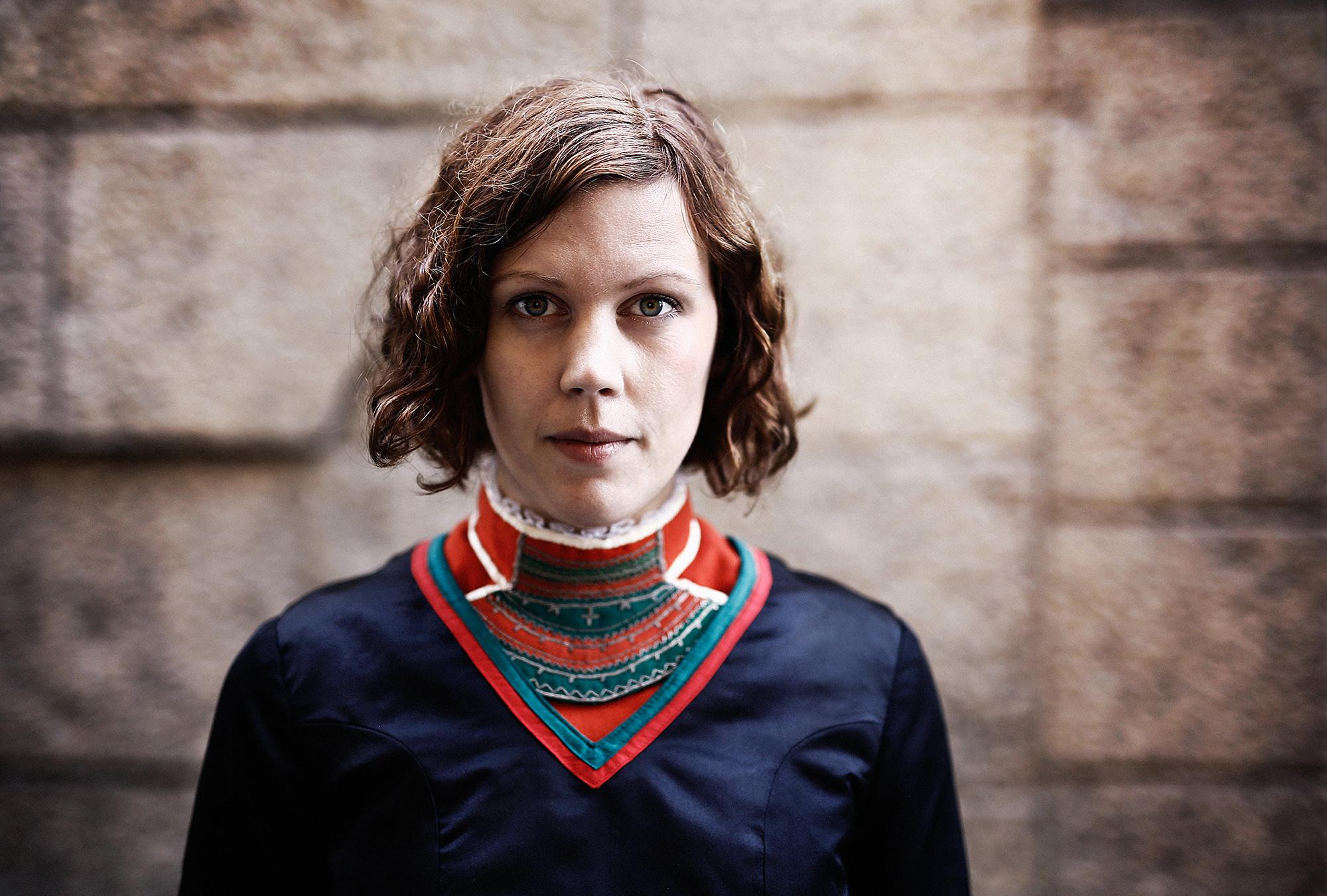 Portrait photo of a woman wearing traditional Sami clothing.