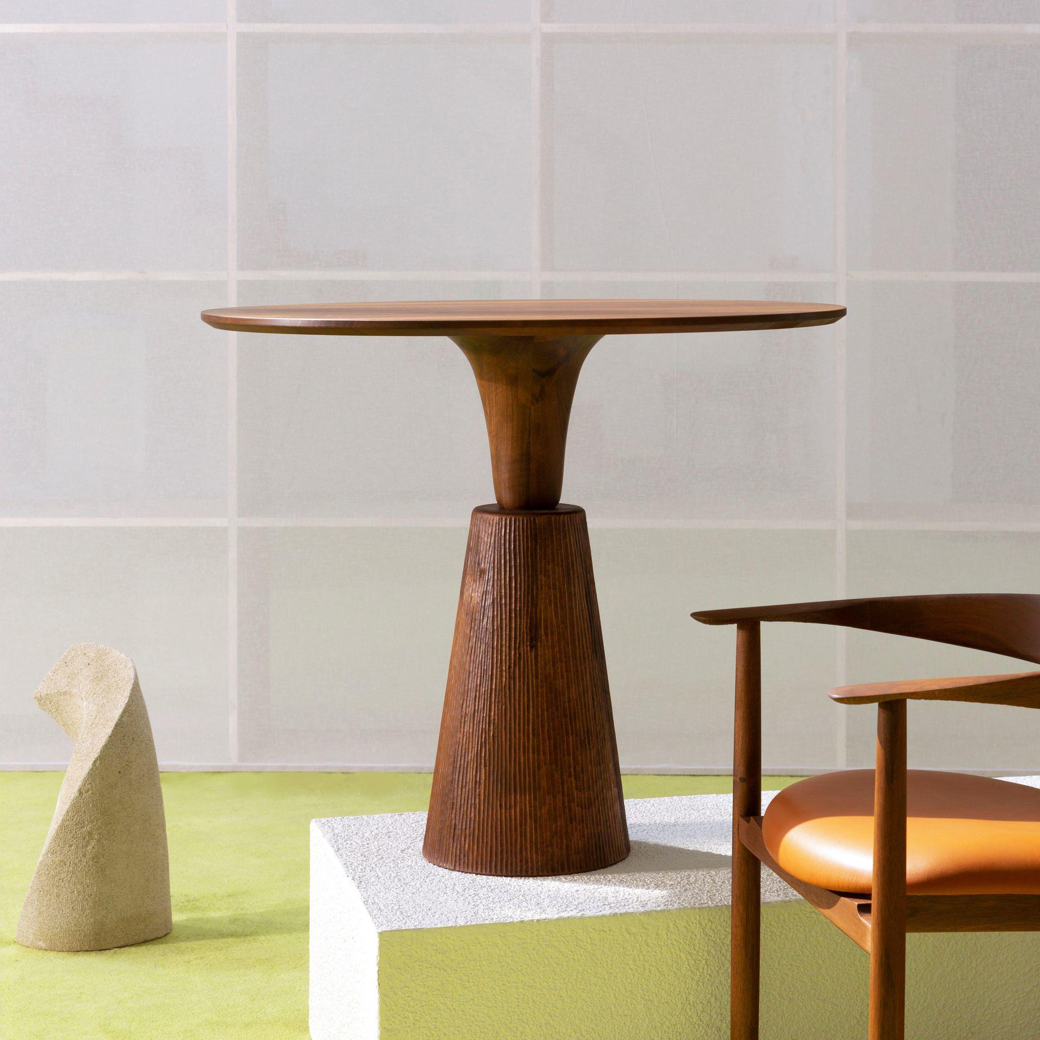 A round brown wooden table on a piedestal.