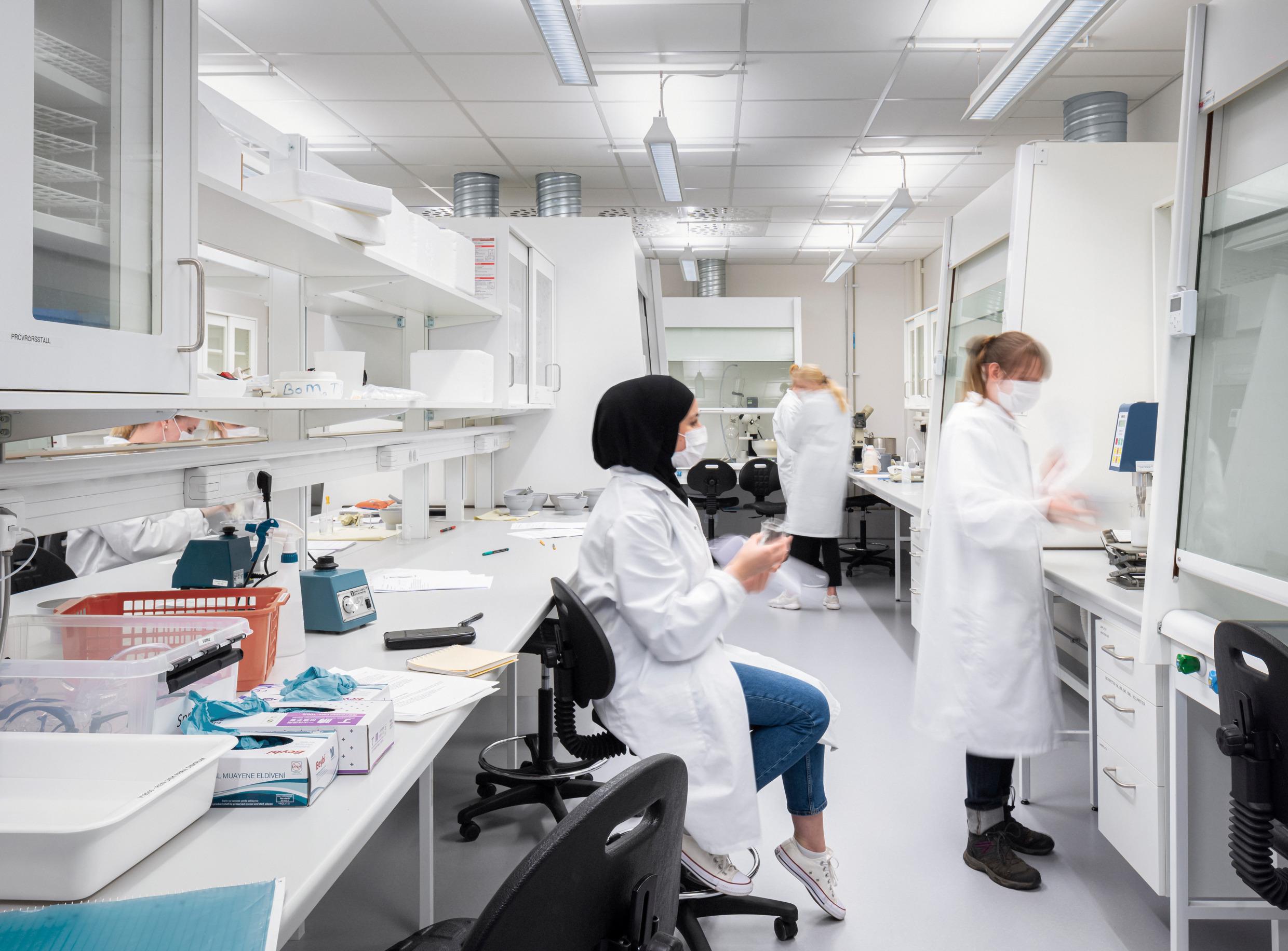 Researchers with face masks in a laboratory setting.