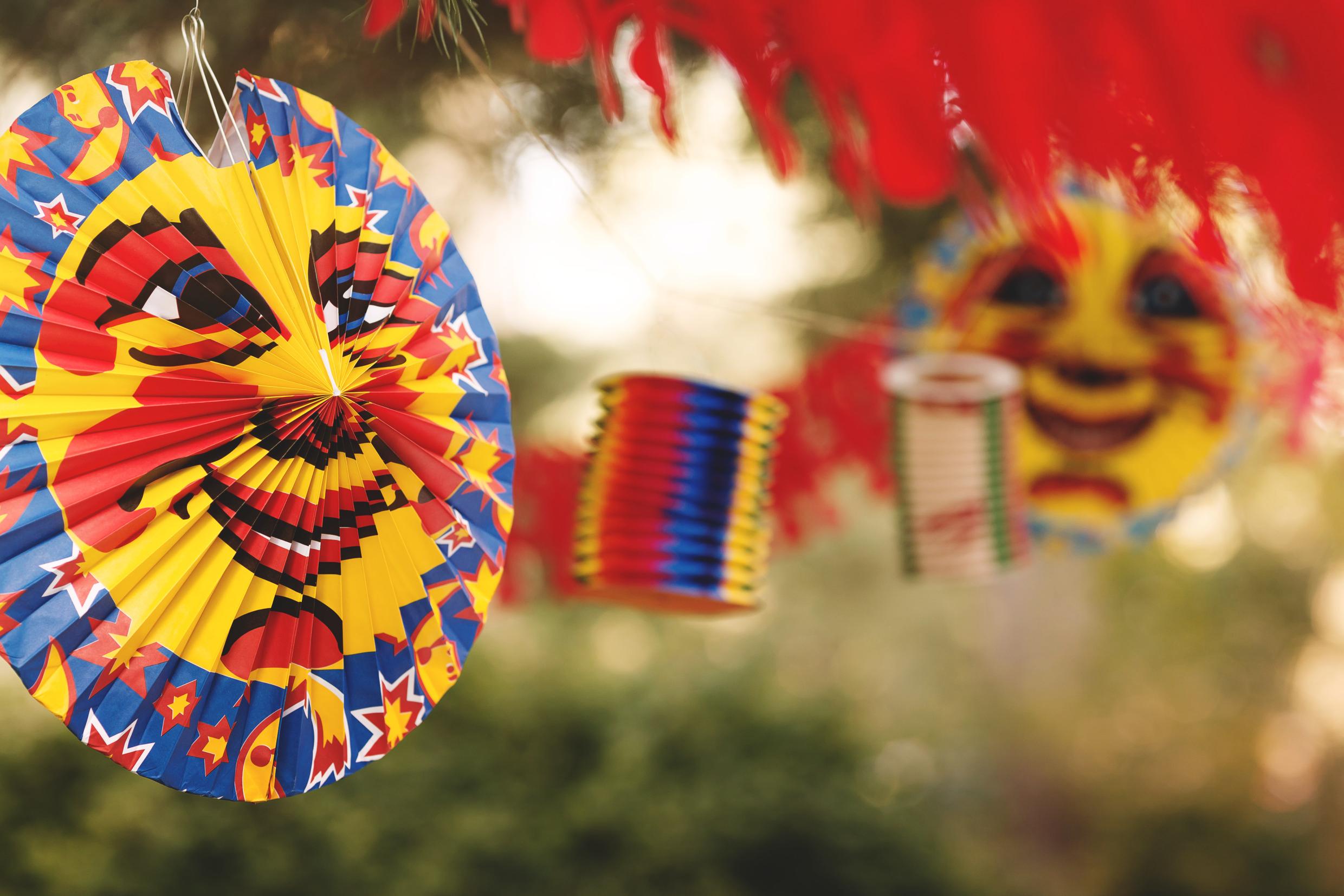 Colourful paper decorations are strung up, some depicting a cartoon moon.