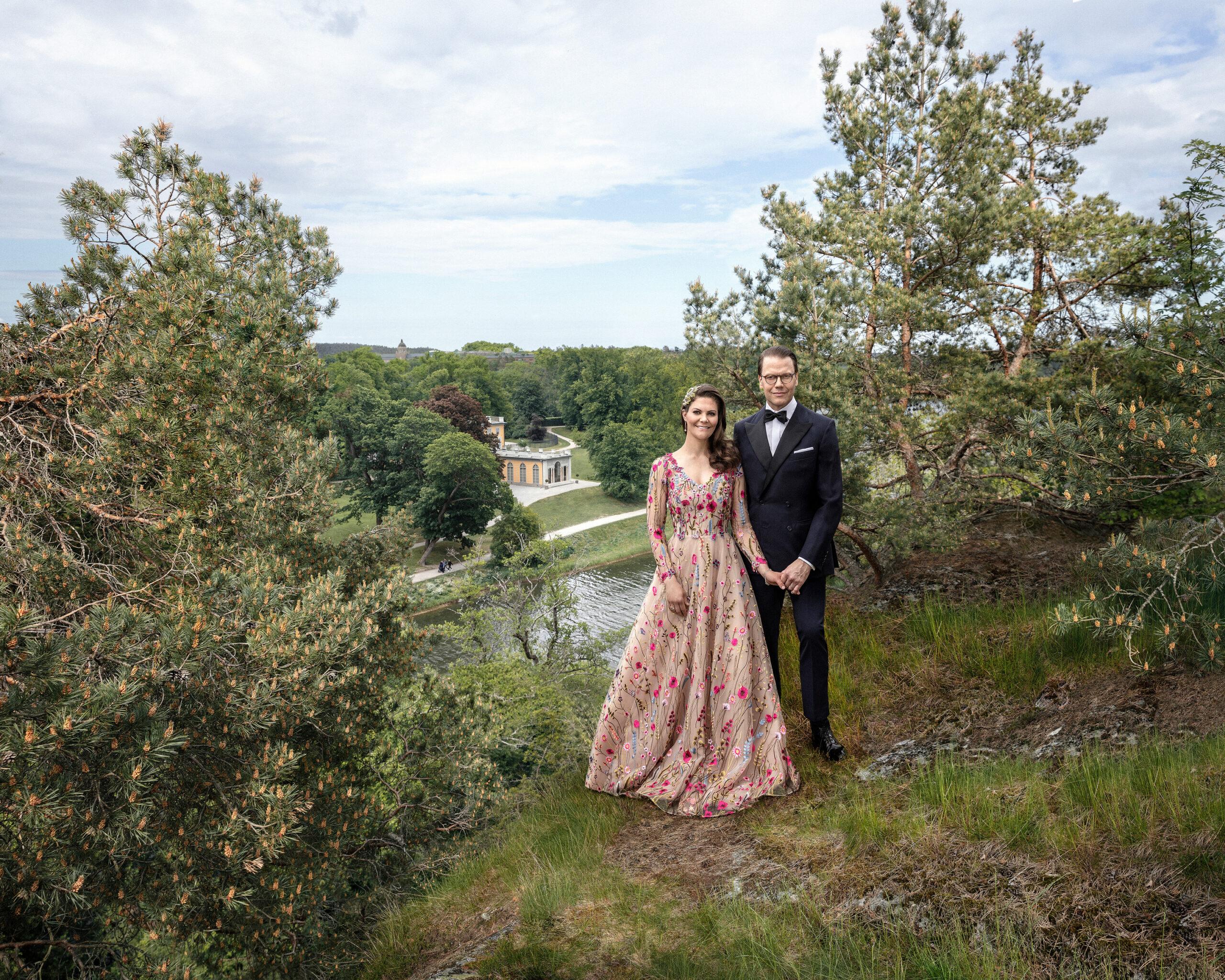 Crown Princess Victoria and Prince Daniel dressed up and standing in a green landscape.