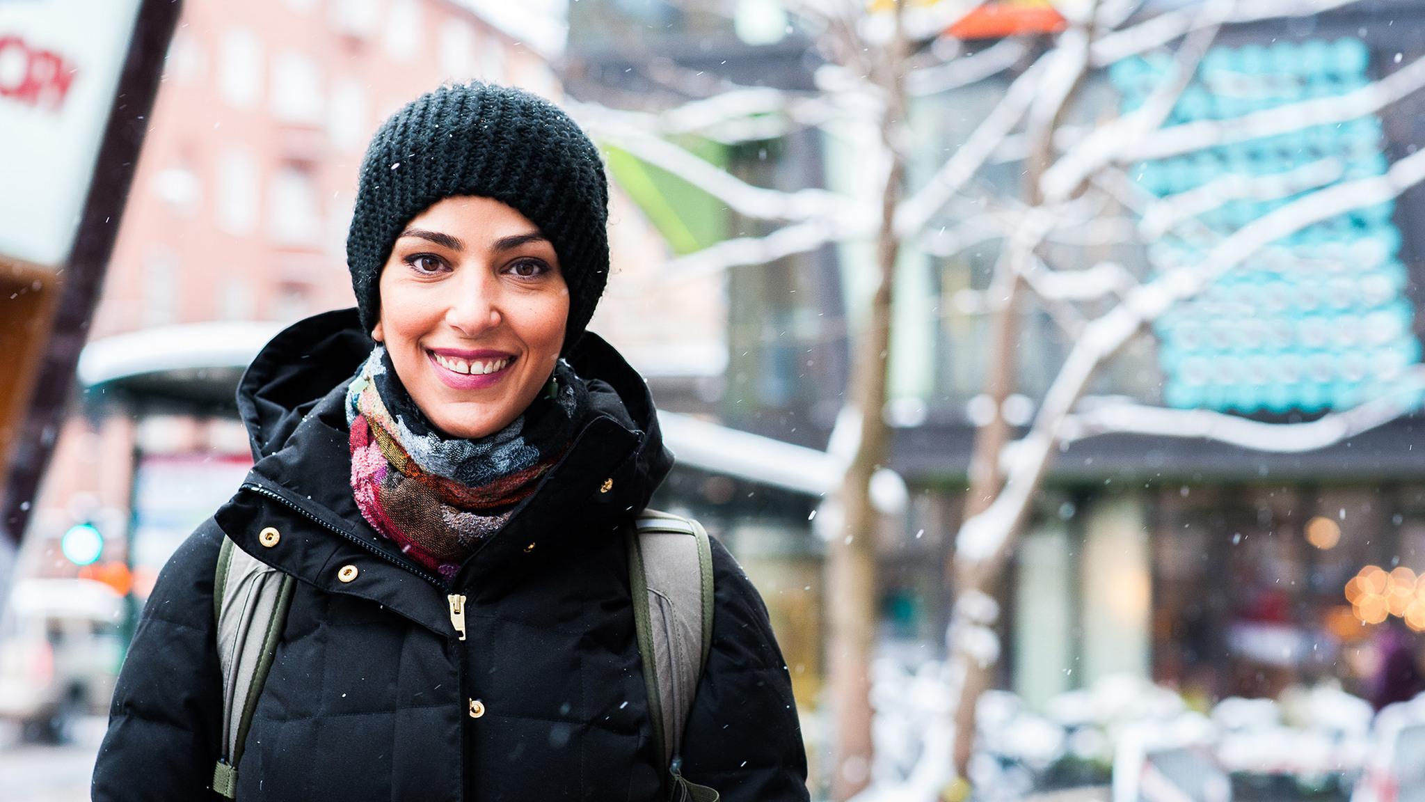 Outdoor portrait of Linda Samir Mutawi wearing a black winter jacket and a woolly hat.