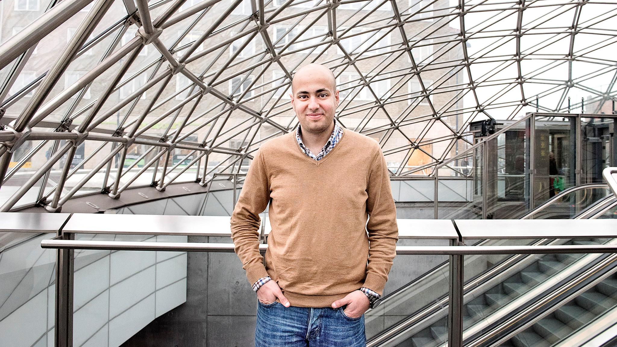 Portait of Mouhanad Sharabati in a dome-like glass building, escalators in the background.