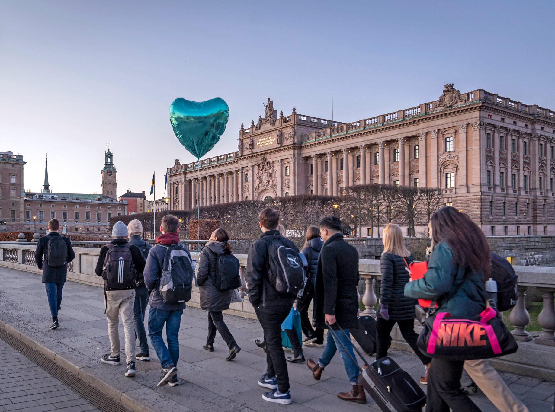 Young people walking outside the Swedish parliament building in Stockholm.