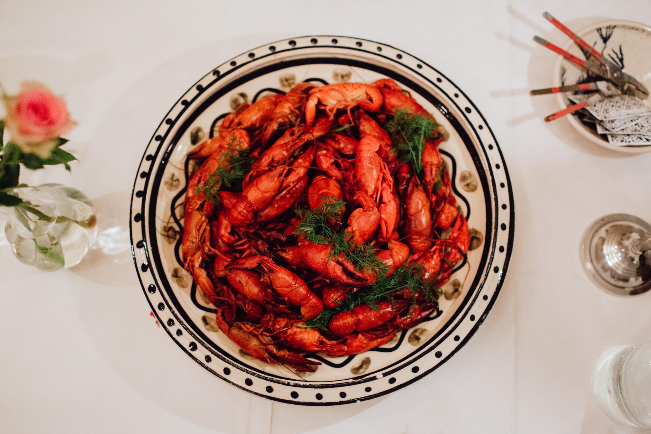 A big bowl of cooked crayfish topped with dill.