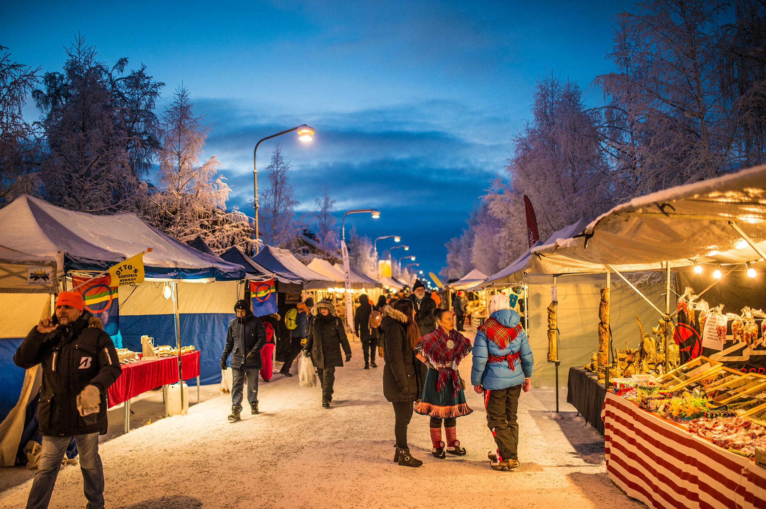 People at an outdoor market in the snow.