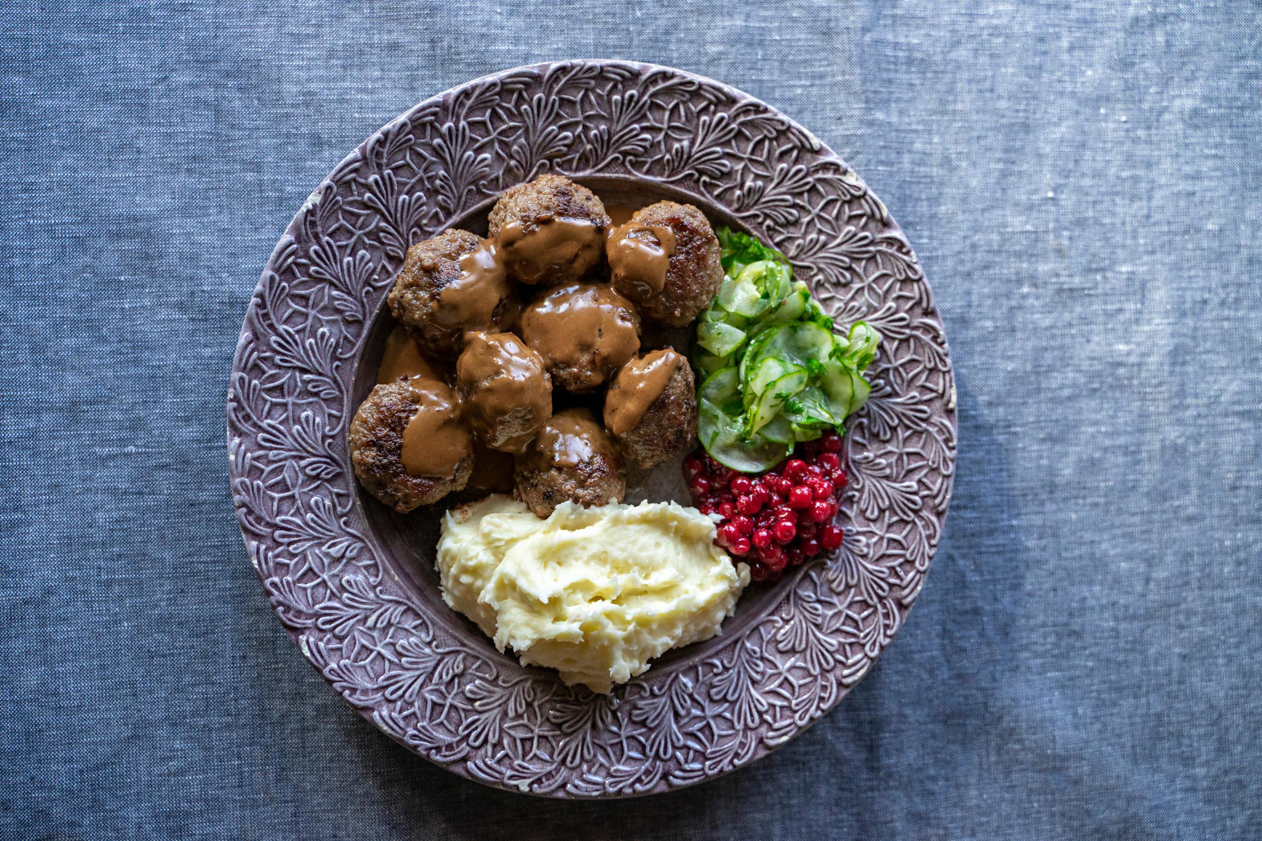 A plate with meatballs and condiments.