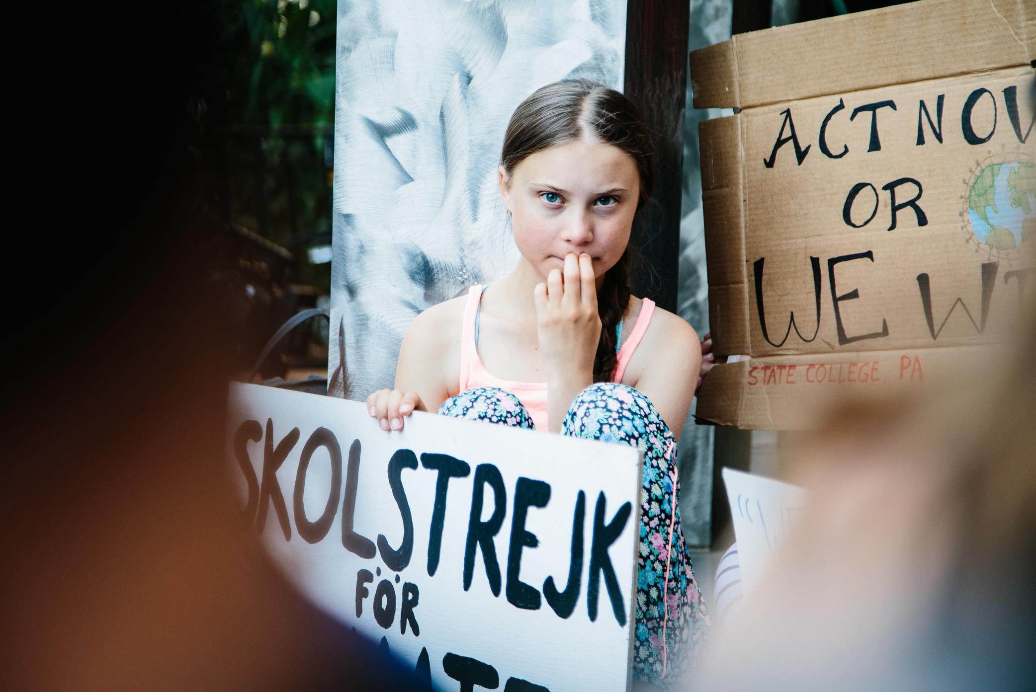 Greta Thunberg with a sign that says 'School strike for the climate'.