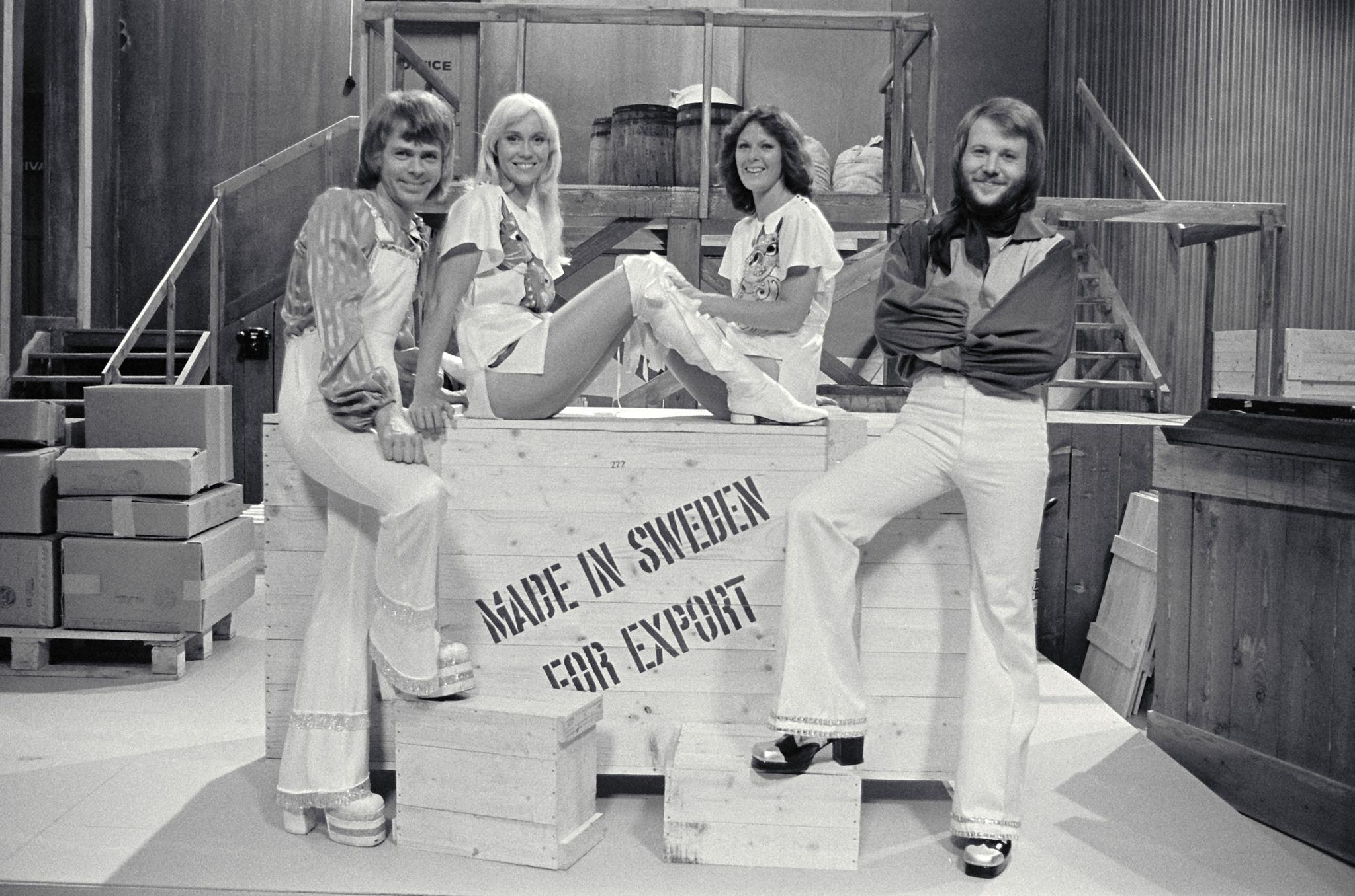 A black-and-white photo of the band ABBA in front of a wooden box with the writing *Made in Sweden for export*.