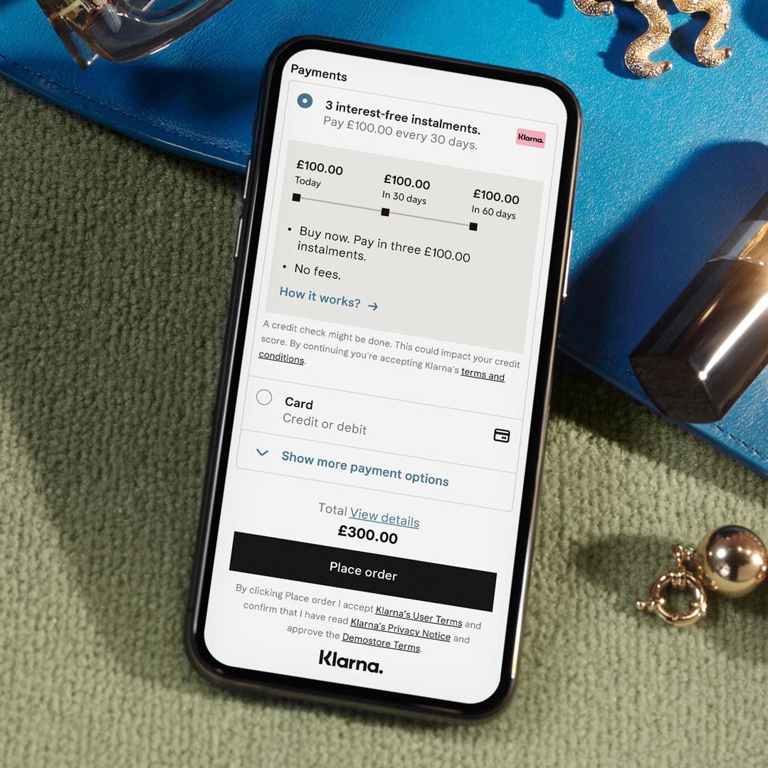 A mobile phone with a page from the Klarna app on the screen.