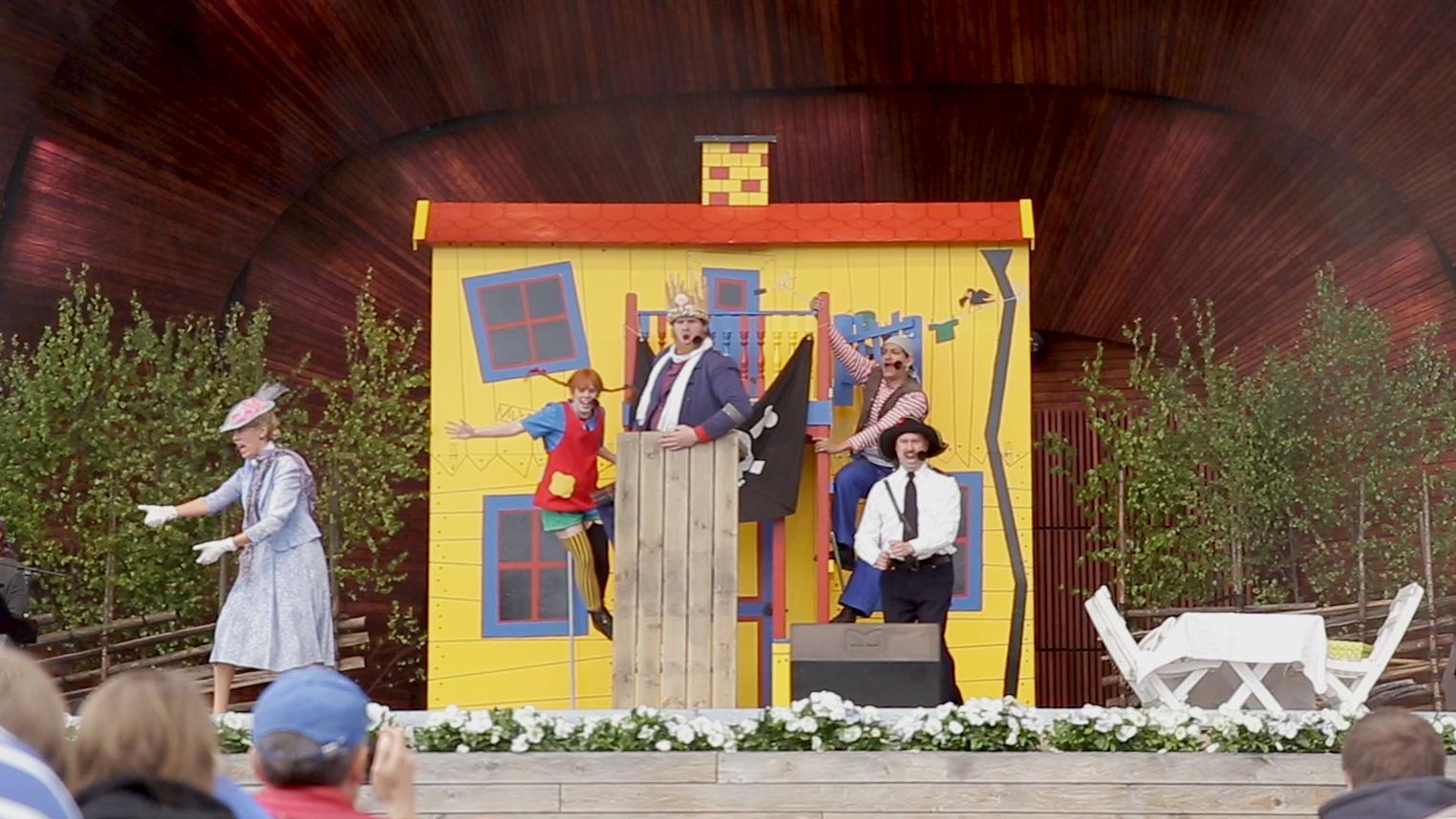 A shot from a Pippi play live on stage. Five actors can be seen.