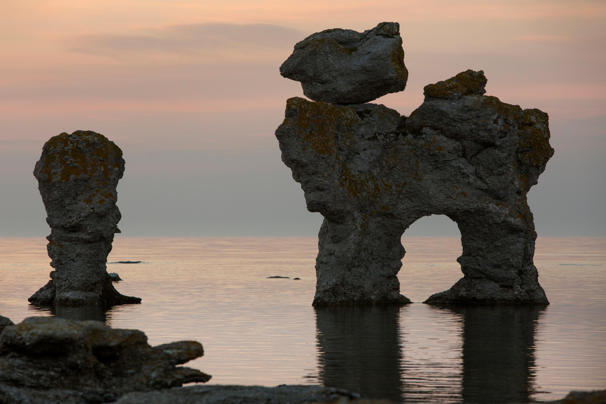 Limestone formations in the ocean at twilight.