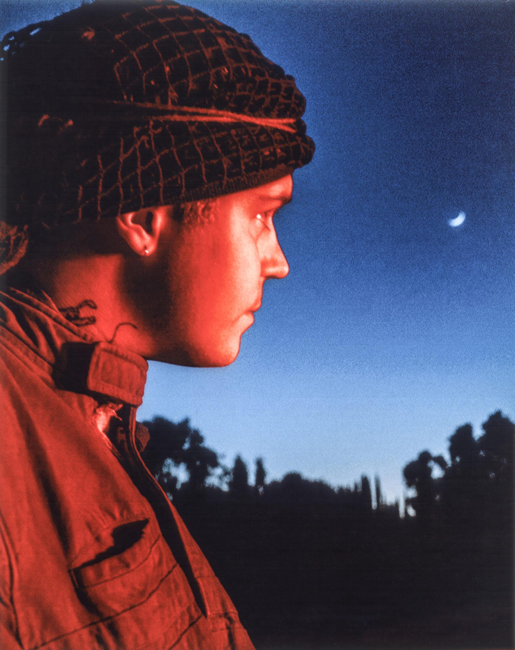 Sideways portrait of Yung Lean against a dark blue night sky.