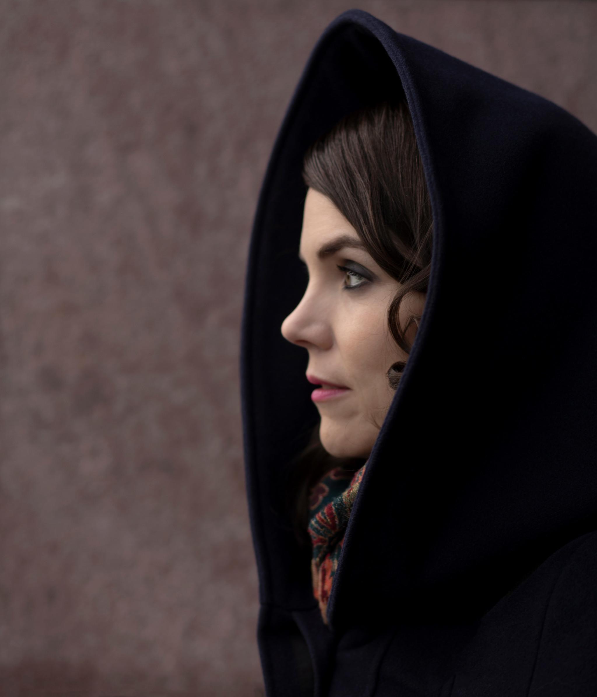 Profile headshot of Andrea Lundgren, wearing a big black hood.