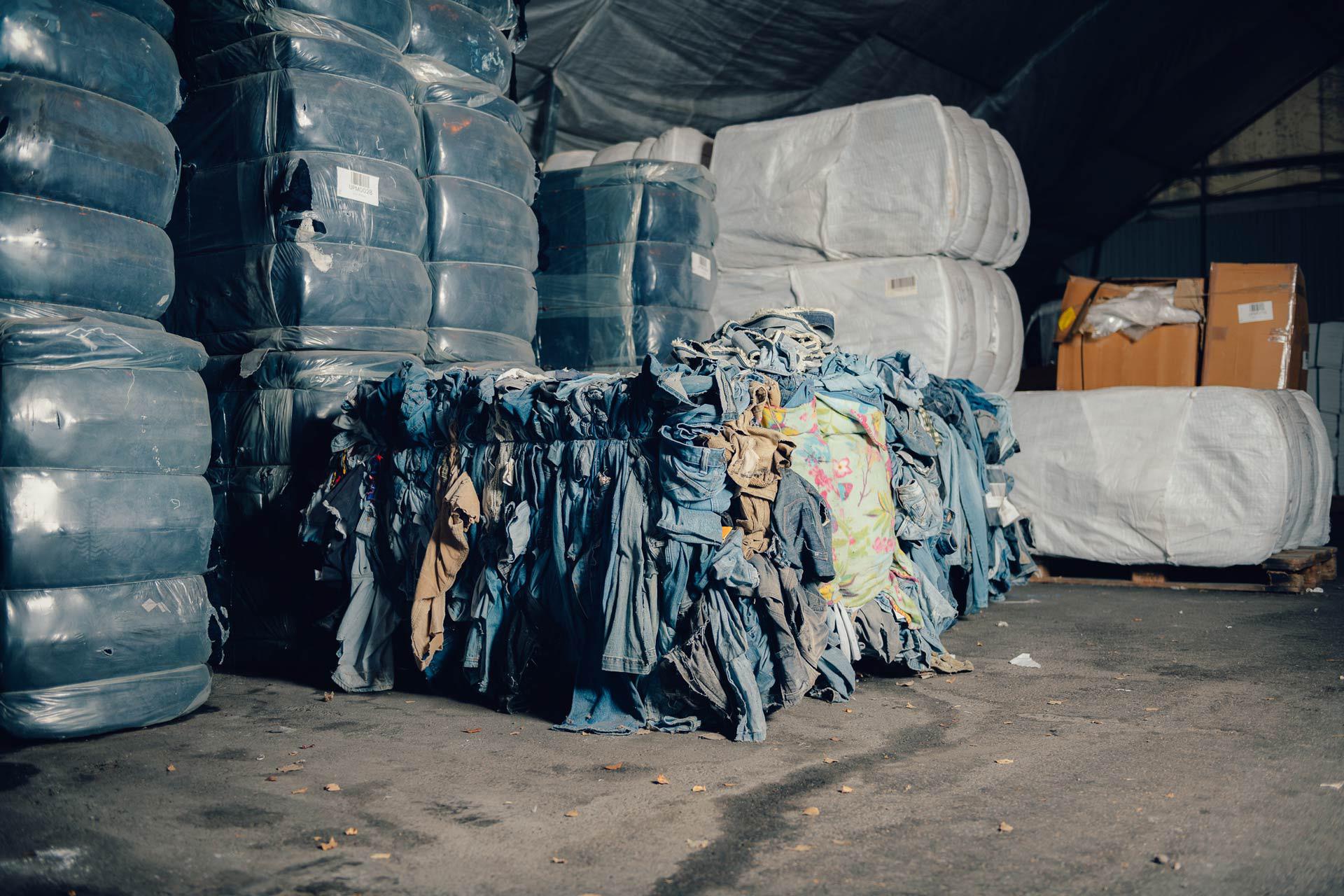 A big pile of recycled clothes in an industrial context.