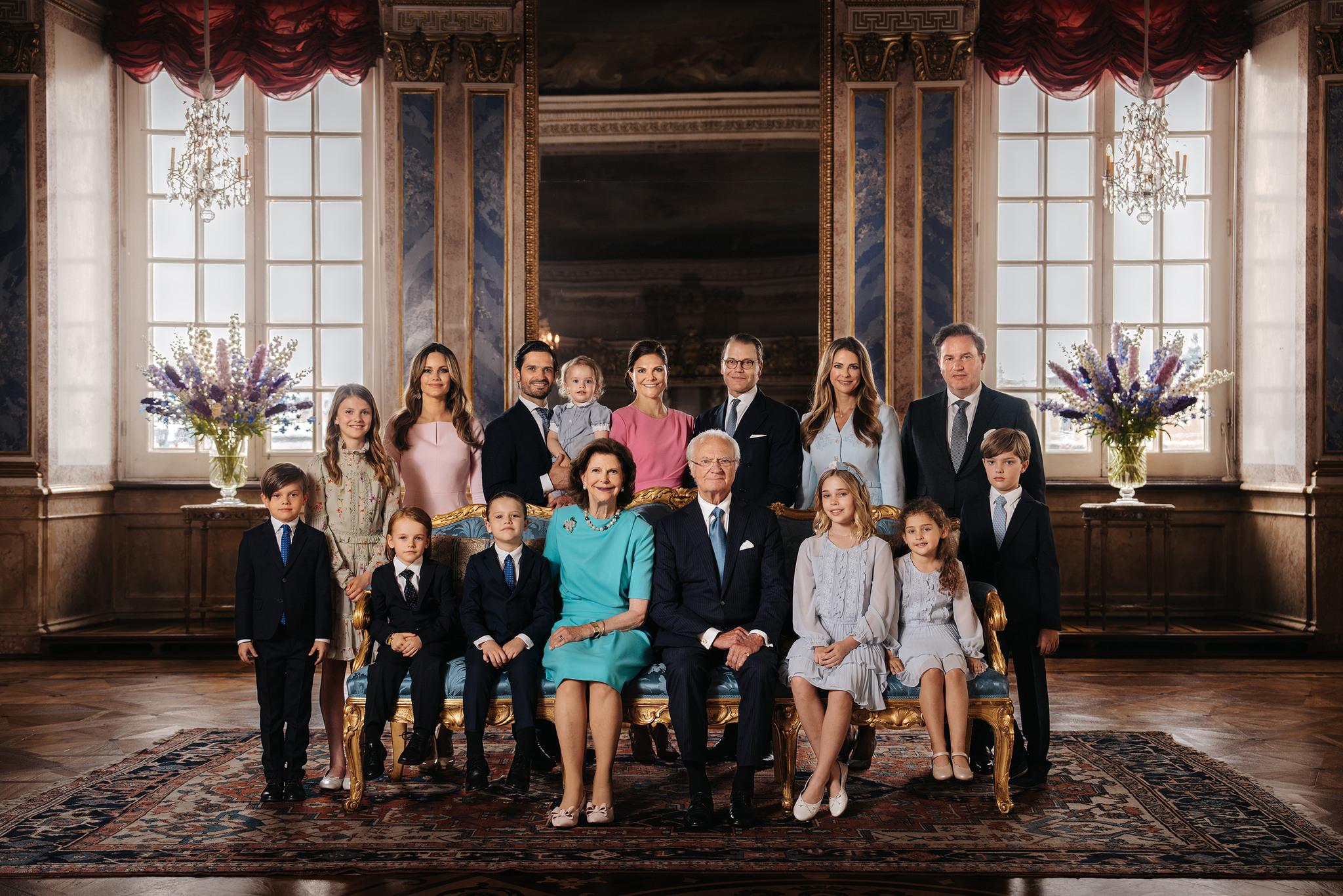 Group photo of the Swedish royal family, some sitting some standing. Taken in a room at the Royal Palace in Stockholm.