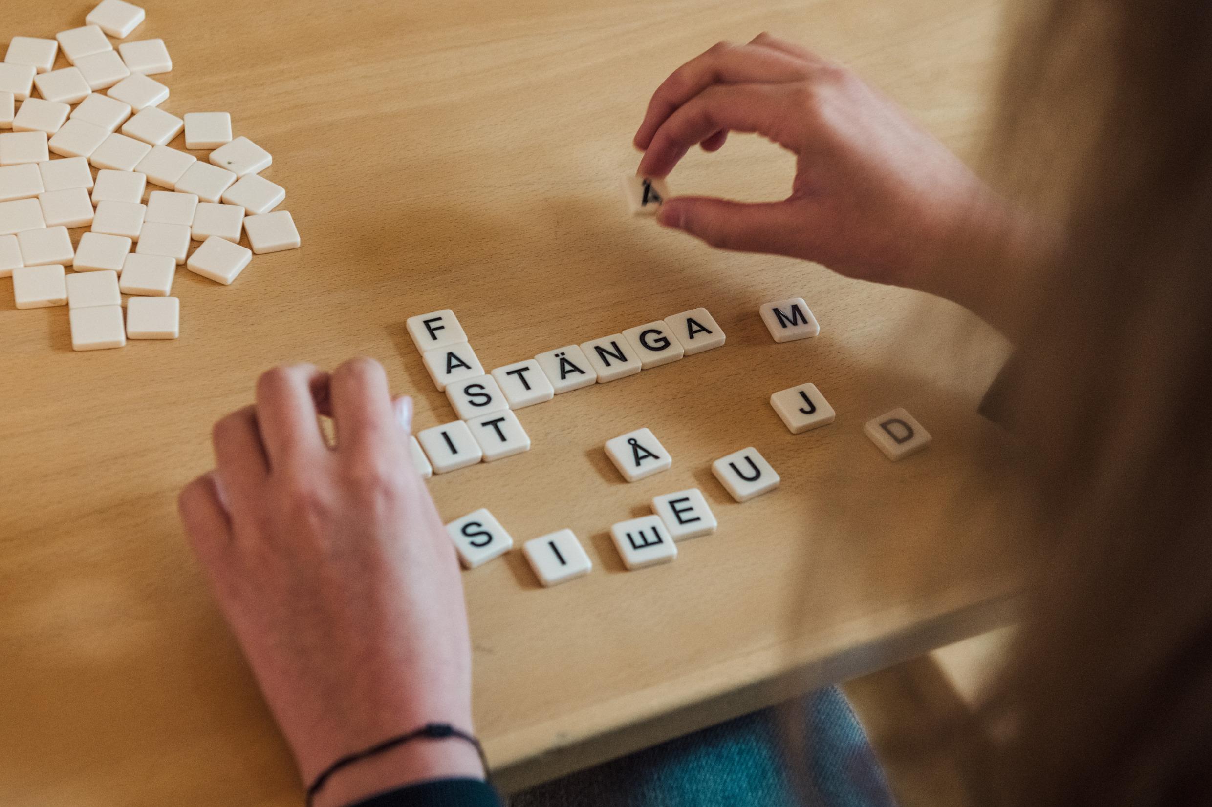 Someone playing Scrabble. Some letters lie on a table.