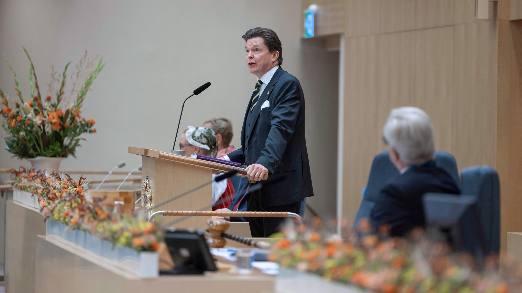 A man stands on a podium, with a microphone. Photo from the Swedish parliament, an important part of Swedish government.