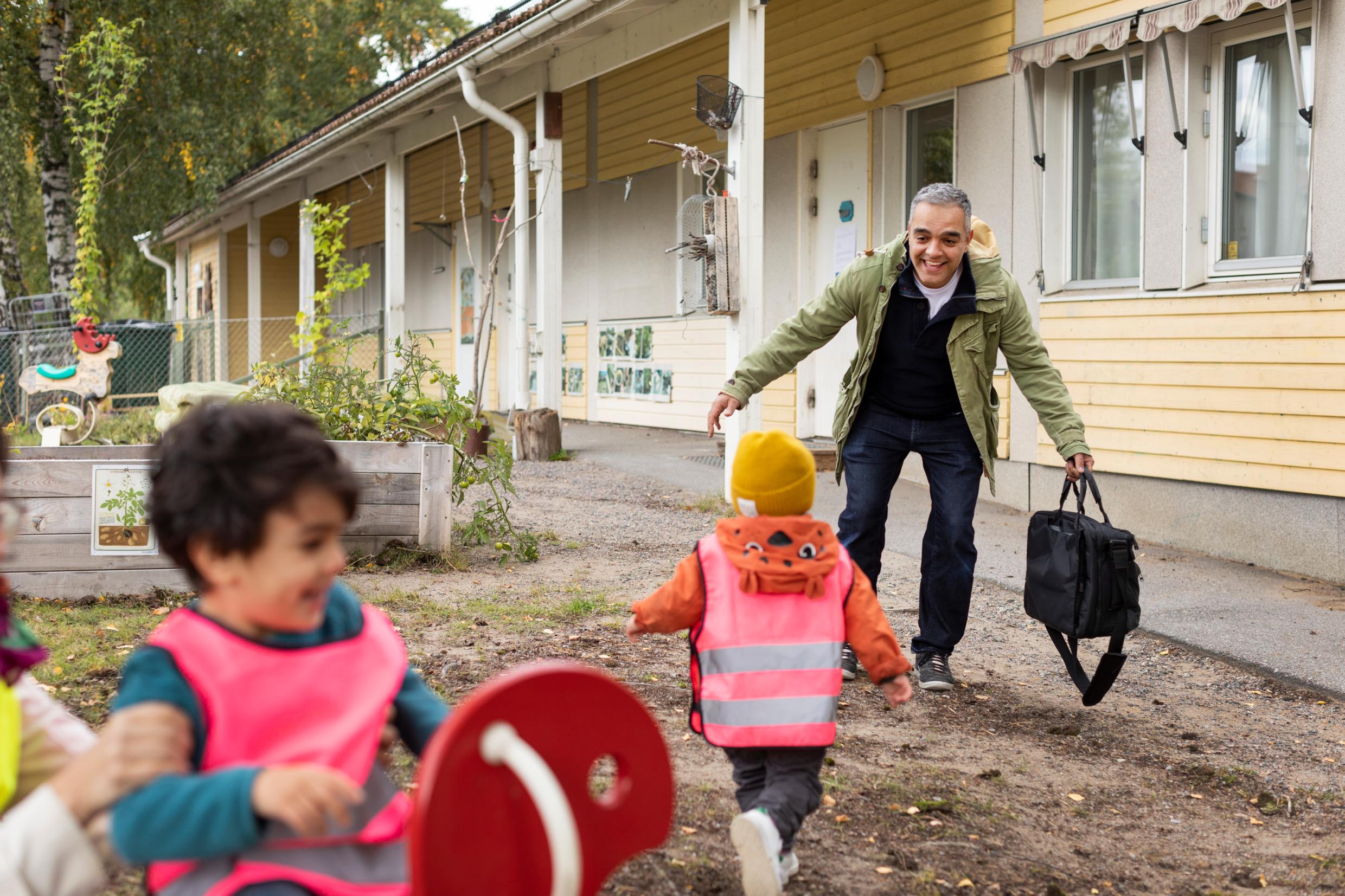A father picks up his child from nursery school. Daycare helps with the work–life balance.