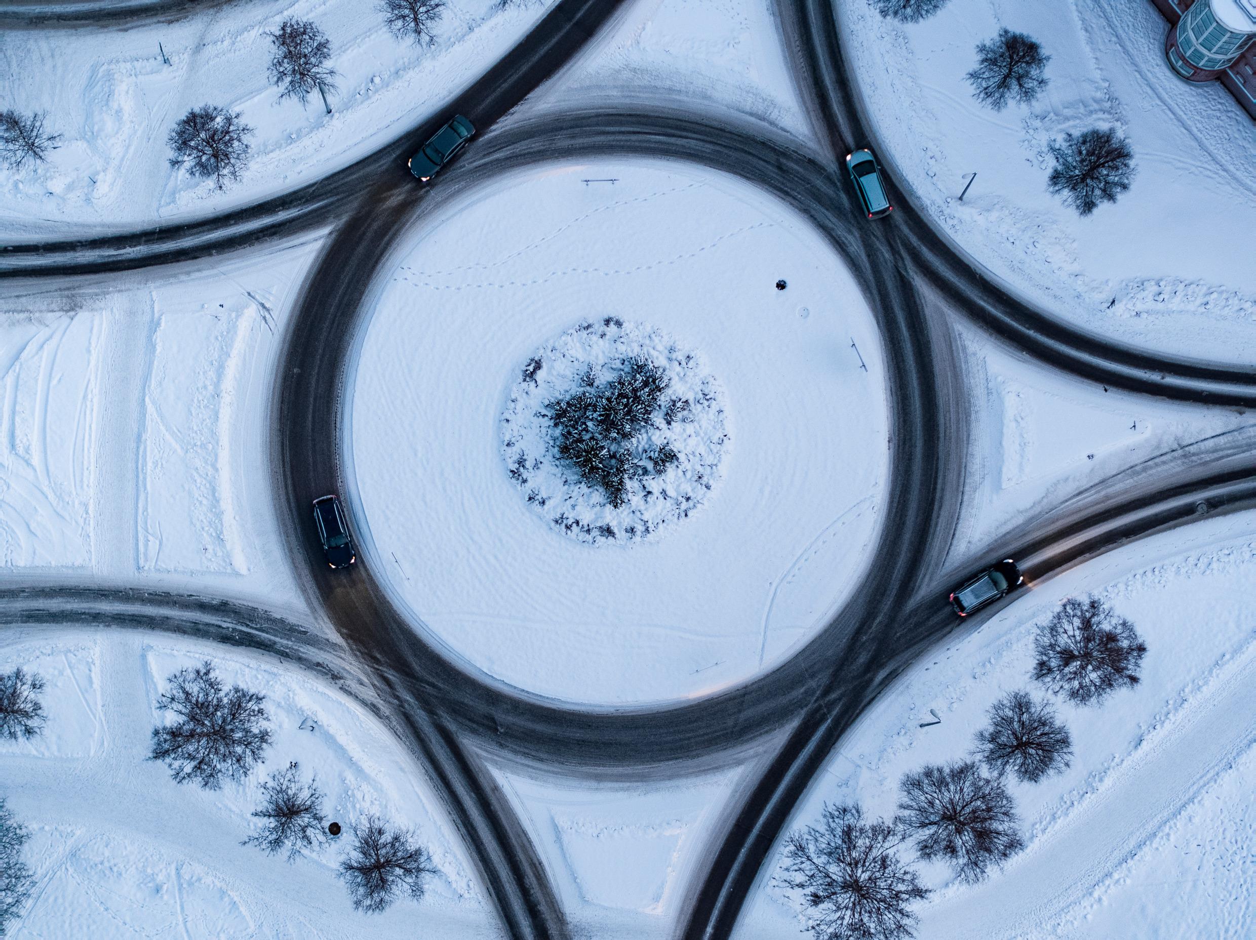 A traffic roundabout seen from above during a snowy winter.